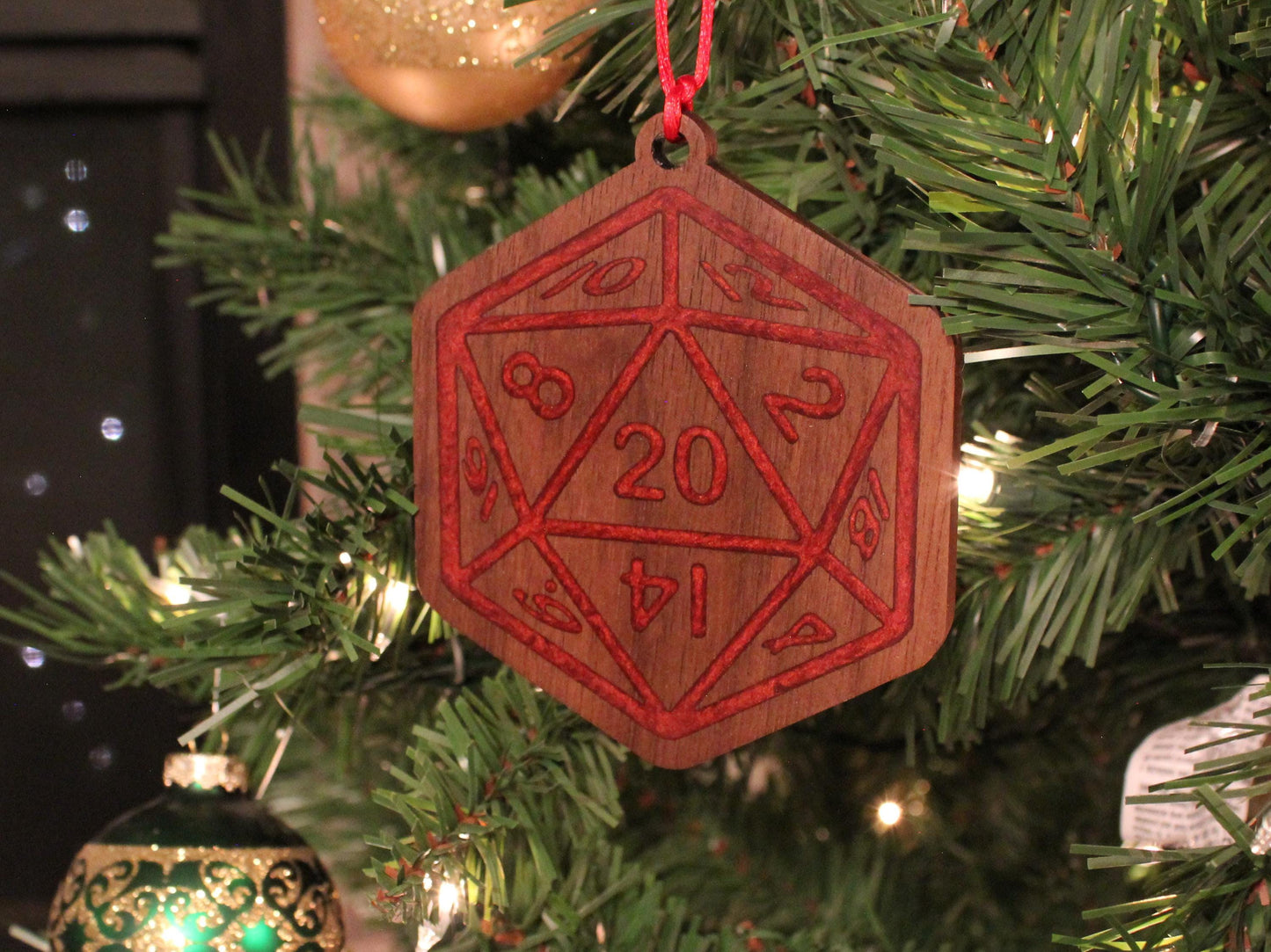 Black Walnut Christmas ornament in the style of a D20 dice, with a red resin infilled engraving.